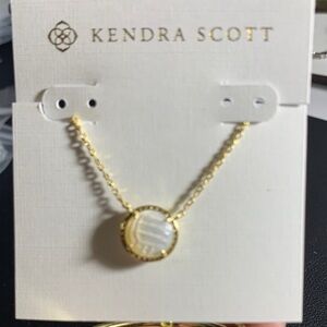 Kendra Scott Gold volleyball necklace.